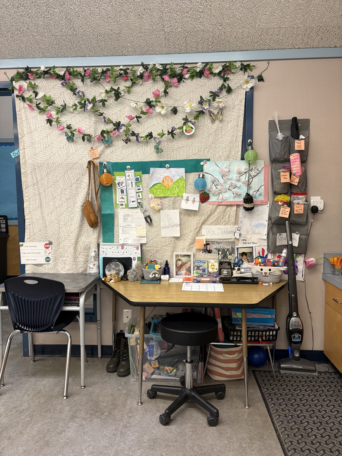 An art and materials station with visual prompts, student work, paper, and drawing tools