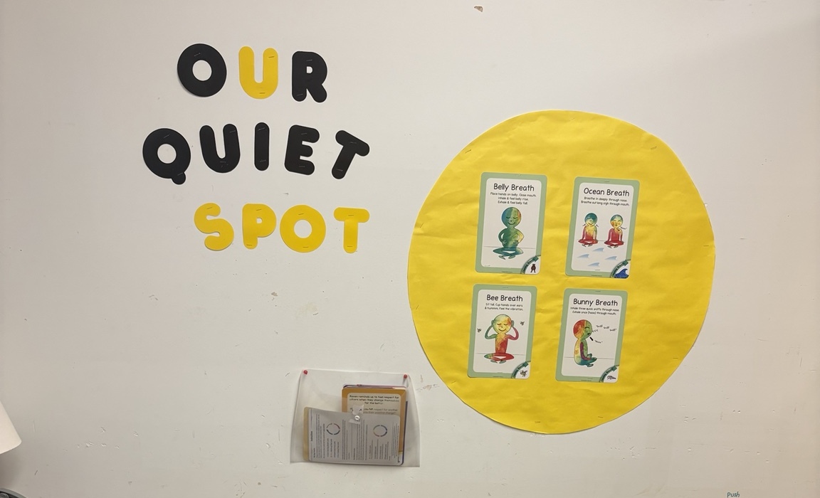 A classroom quiet spot with a cushion and a small visual choice board