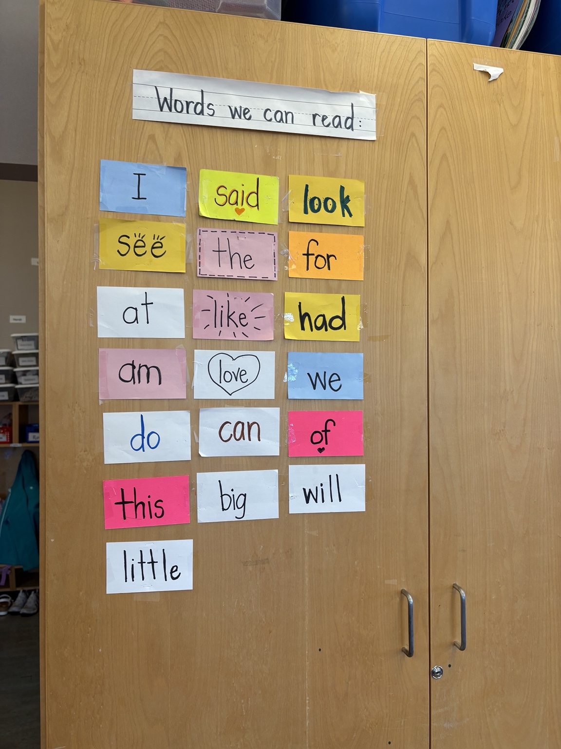 Frequently used words printed on colourful cards and displayed on a classroom cupboard