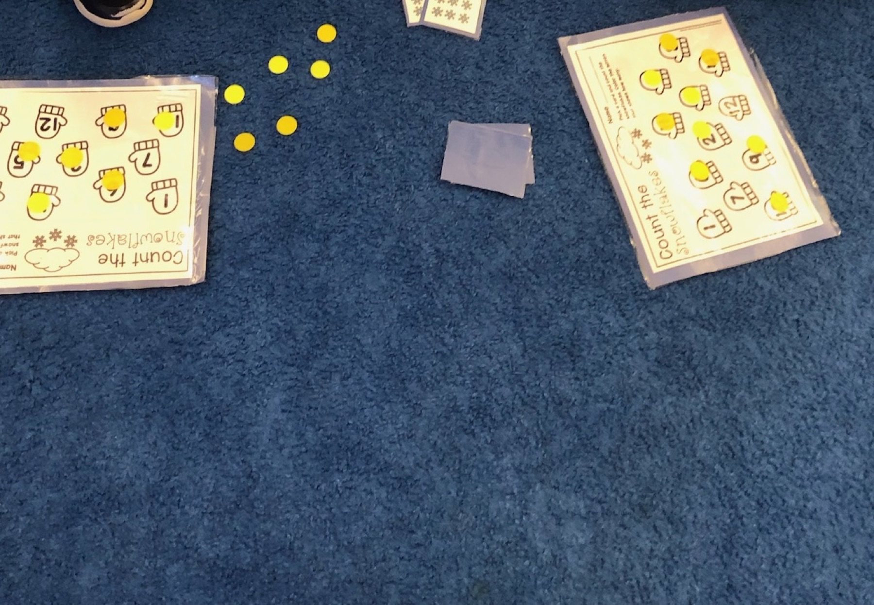 Winter counting cards and counters arranged on a classroom carpet